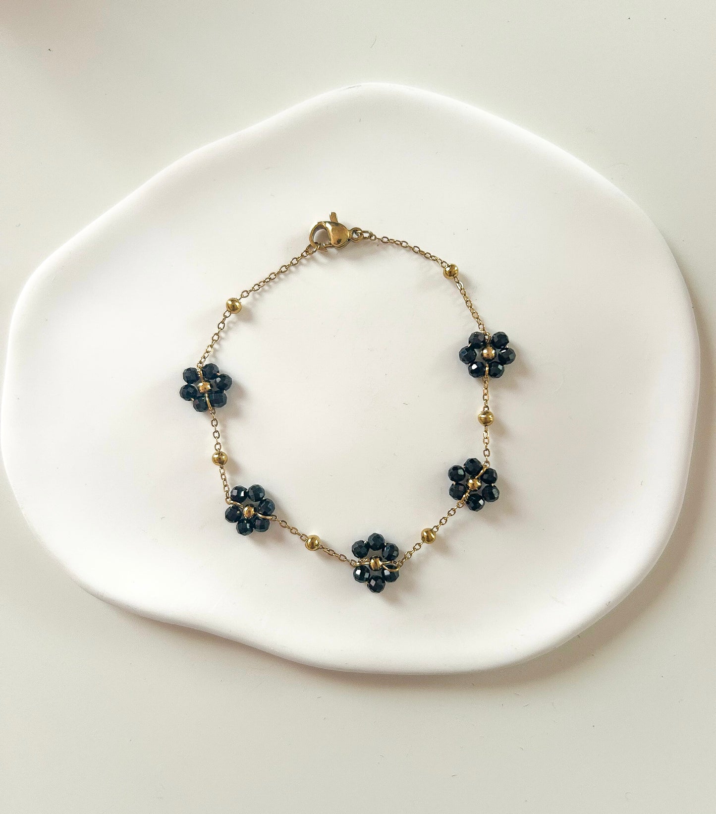 Bracelet doré avec 5 fleurs noires