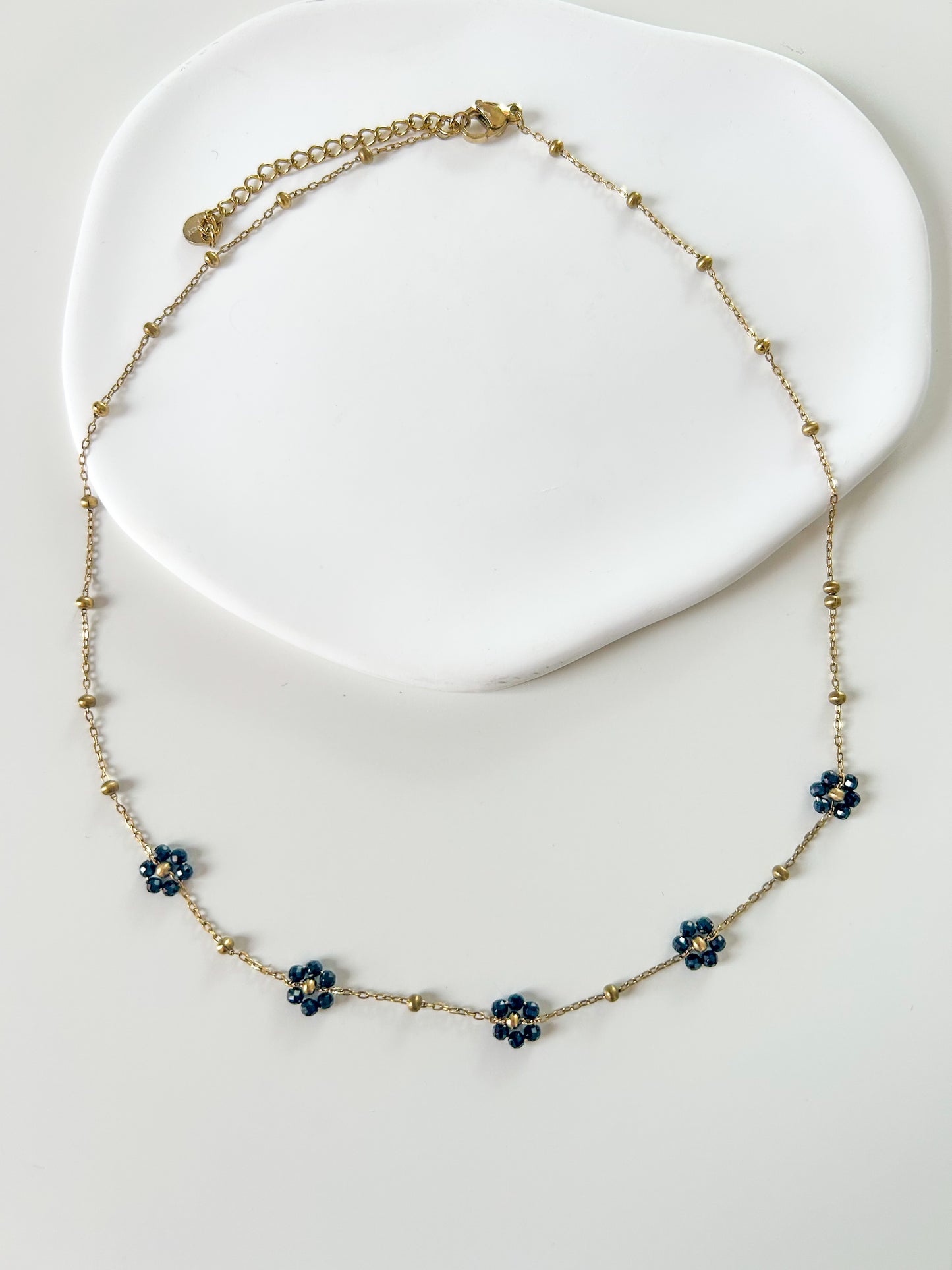 Collier doré avec 5 fleurs noires – chic & élégant