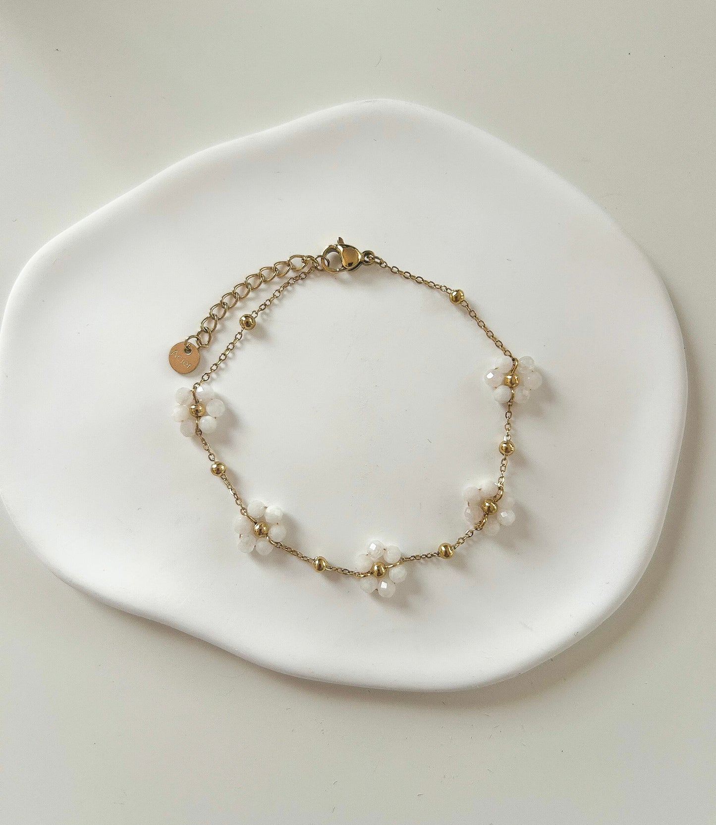 Bracelet doré avec 5 fleurs blanches